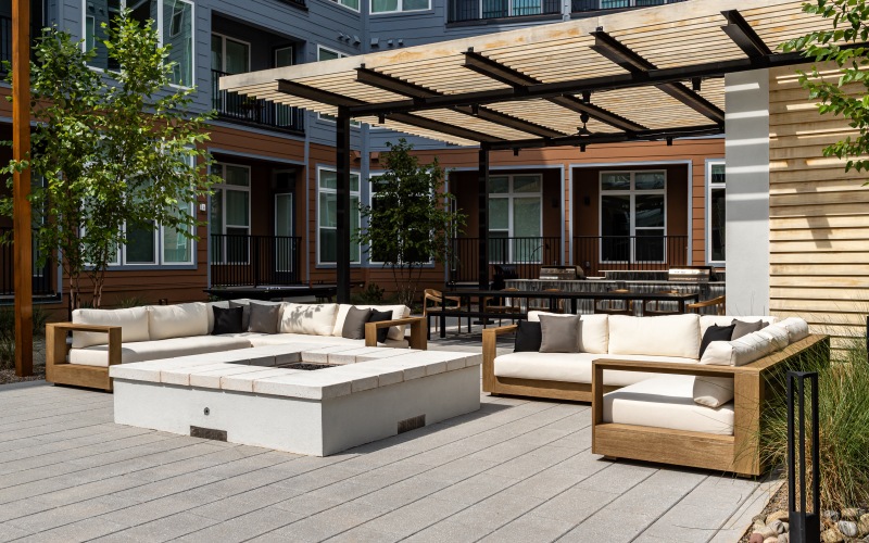 ample cushioned seating surrounds a large square firepit