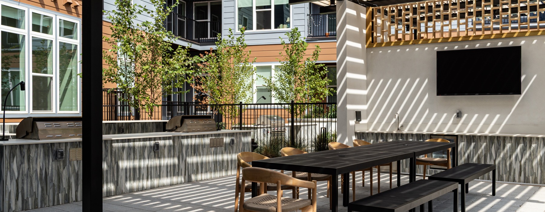 a pergola over outdoor dining area and kitchen with multiple grills